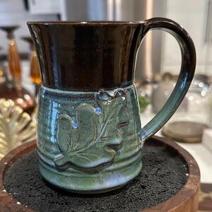 handcrafted studio pottery mug featuring a distinctive oak leaf and a two-tone